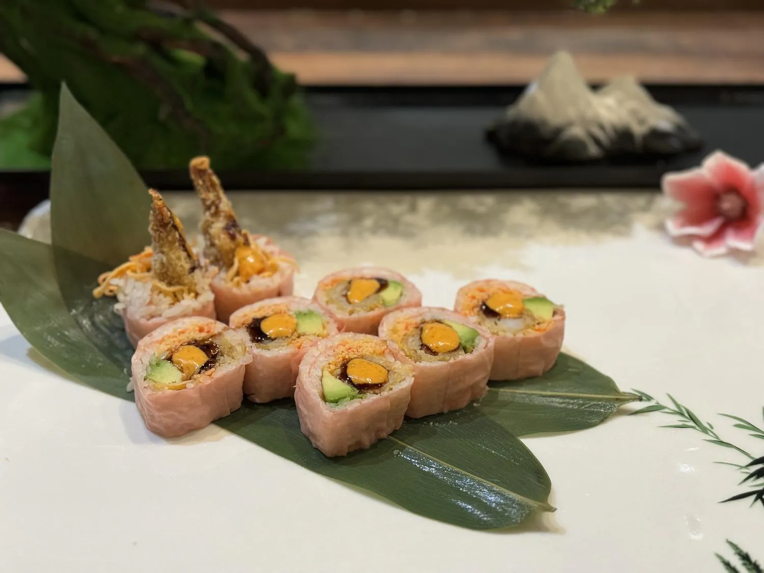 Sushi roll wrapped in pink soy paper with shrimp tempura, avocado and mango at Sushi Kingdom Glen Allen, a Japanese Restaurant in Glen Allen